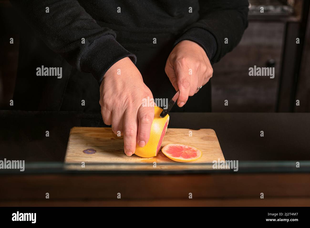 ROSAFARBENE GRAPEFRUITSCHEIBEN SCHNEIDEN. Stockfoto