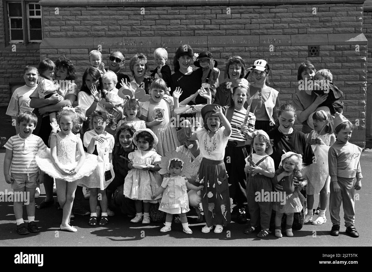 Lustige Zeit... Jugendliche in schicken Kleidern genießen die Sonne bei einem lustigen Tag im Birkby Community Center, das organisiert wird, um Geld für den Kinderkrebsfeiertag zu sammeln. Die Veranstaltung hob £257 für die Wohltätigkeitsorganisation, die Zoe Featherstone, von Birkby, in den Urlaub zu senden. Jugendliche nahmen am lustigen Tag an einem Kostümwettbewerb Teil und die Eltern hatten die Möglichkeit, Artikel von einem neuwertig gekauften Stand zu kaufen. 26. Mai 1992. Stockfoto