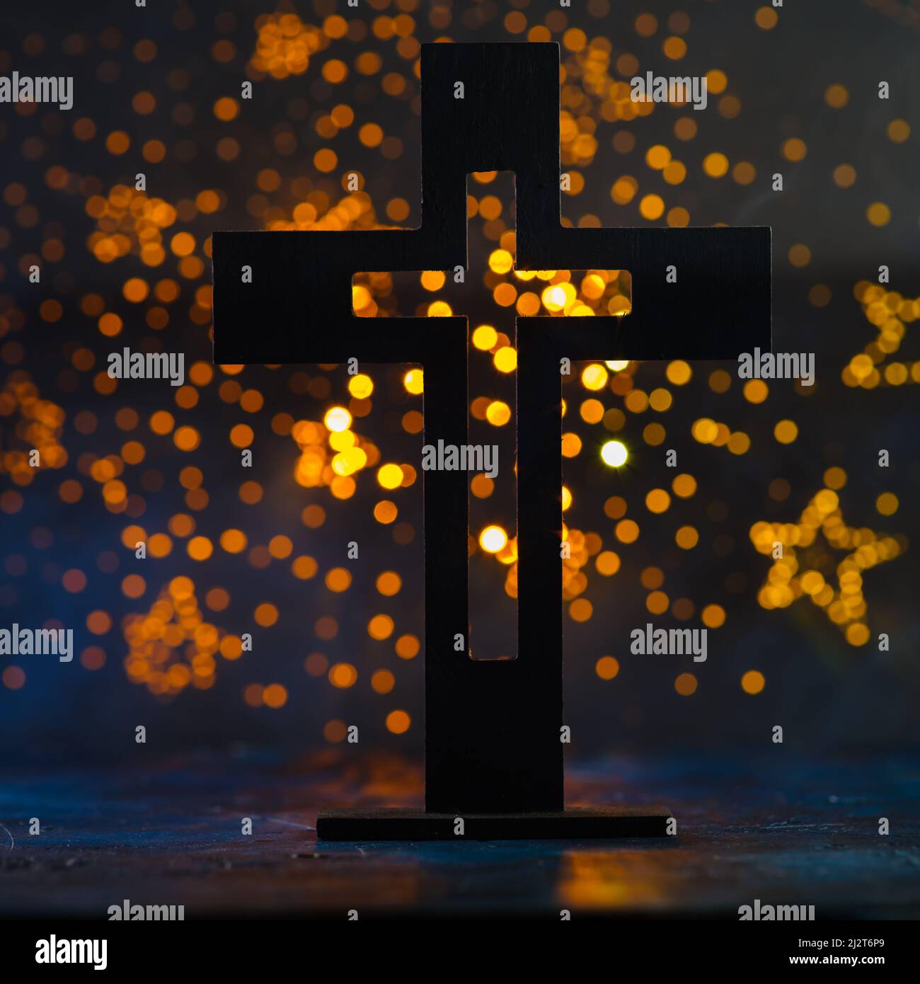 Auf einem gelben Hintergrund mit Sternen ist ein großes katholisches Kreuz zu sehen. Symbol des Glaubens, der Spiritualität, der Liebe. Religion, Christentum, Spiritualität, Glaube, Gebet, Stockfoto
