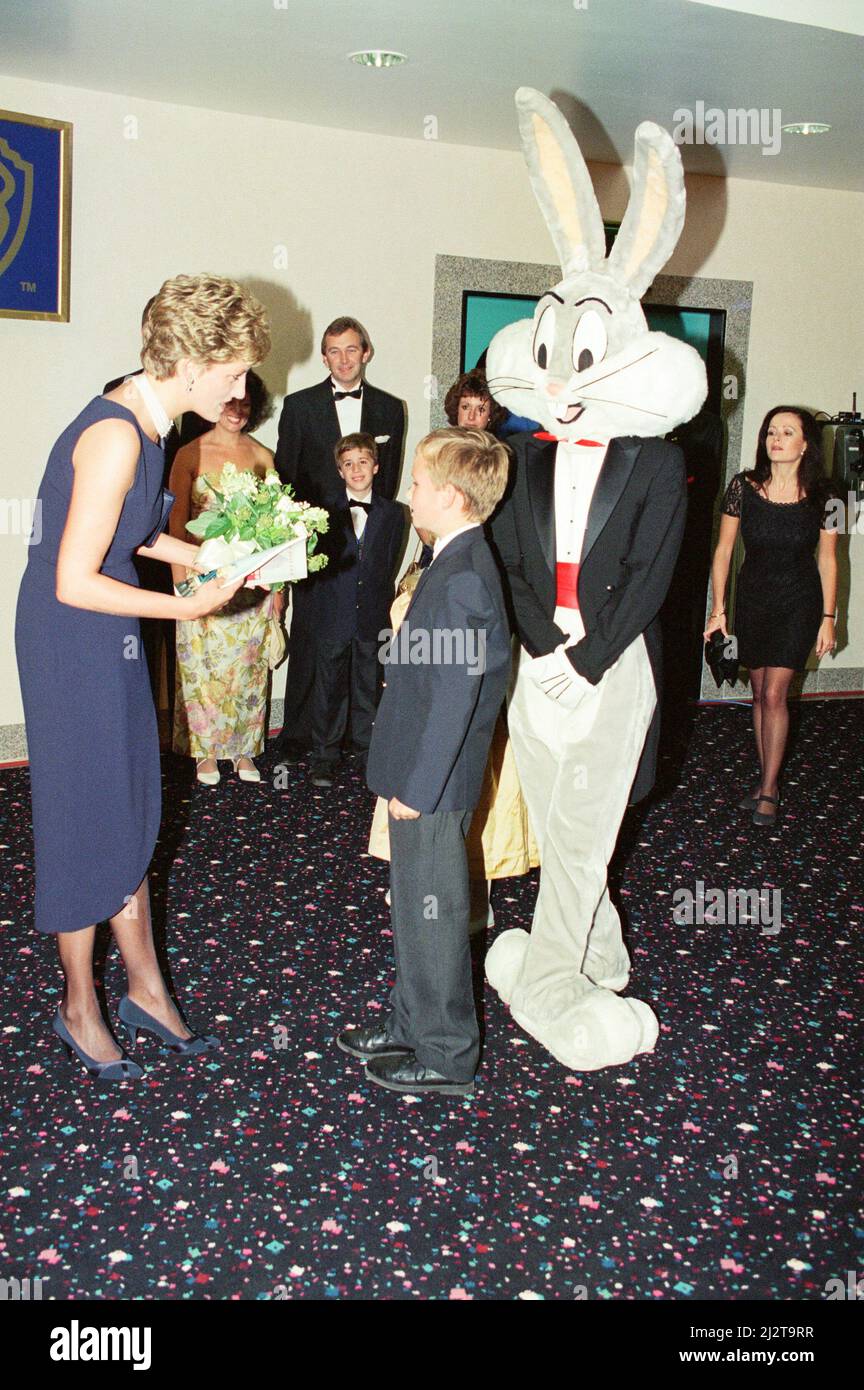 Prinzessin Diana, die Prinzessin von Wales, im neuen Warner West End Kino im Leicester Square London, zur Premiere von The Fugitive. Diana wird von einem jungen Mädchen mit einigen Blumen überreicht, während jemand in einem Bugs Bunny Kostüm den Moment ebenfalls genießt. Bild aufgenommen am 23.. September 1993 Stockfoto