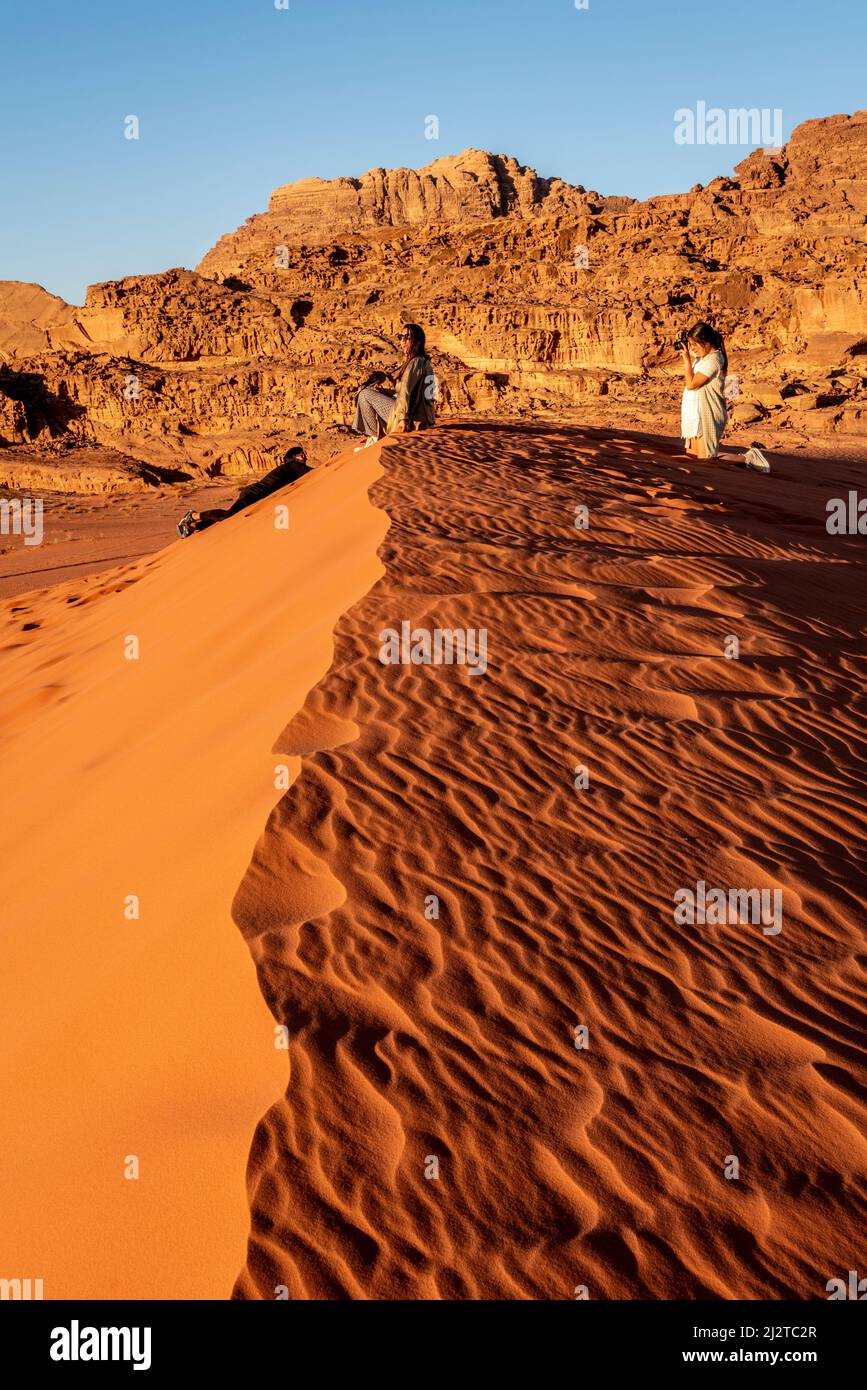 Eine Gruppe junger weiblicher Touristen in der Red Sand Dune, Wadi Rum, Jordanien, Asien. Stockfoto