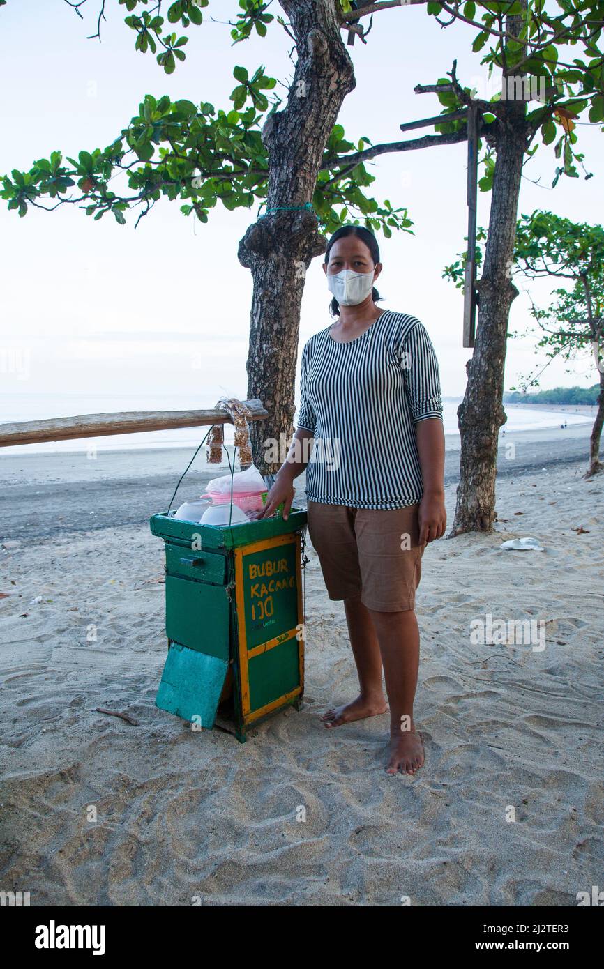 Eine Frau, die am frühen Morgen Bubur ijo oder grüne Bohnensuppe am Kuta Beach, Bali verkauft. Stockfoto