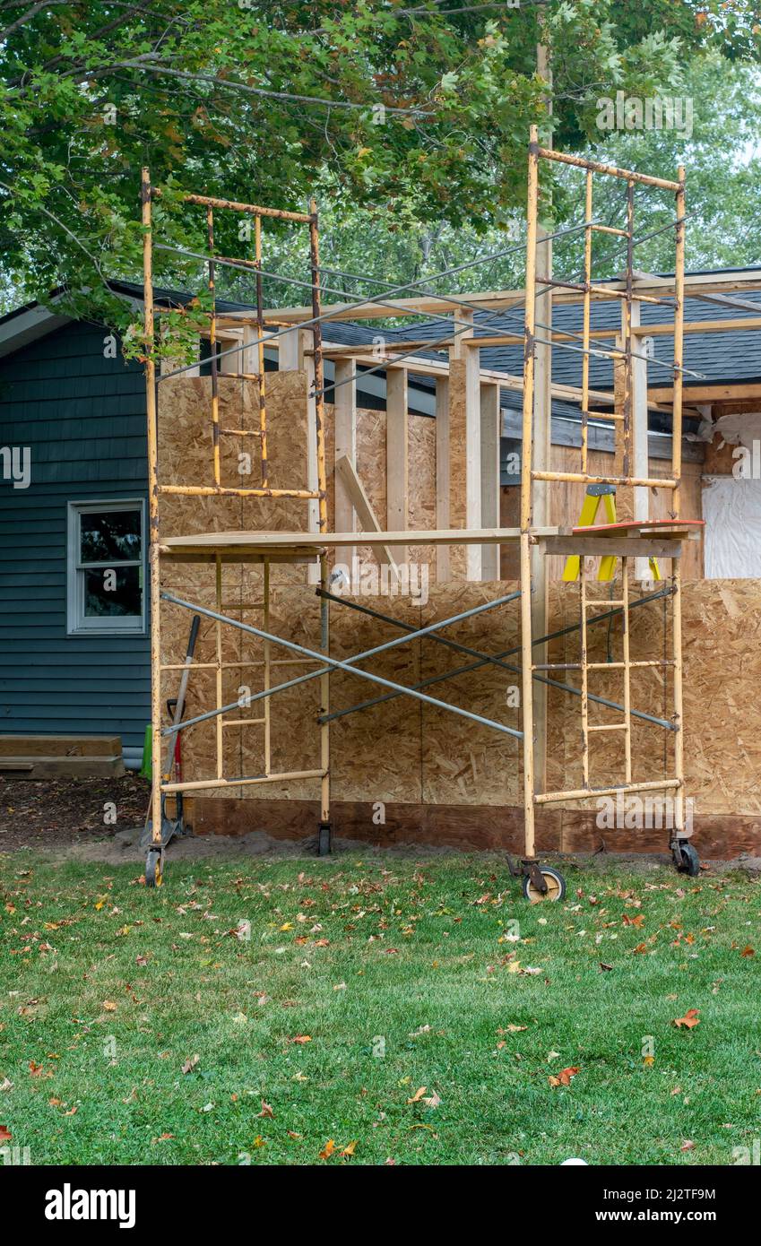 Gerüste werden errichtet, um die Holzfolien für einen neuen Raumzubau aufzusetzen Stockfoto