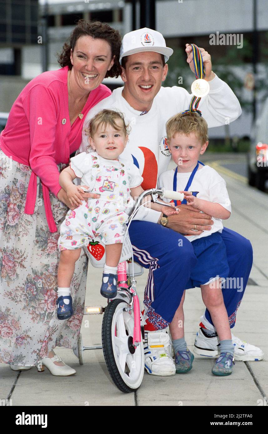 Der britische Radfahrer Chris Boardman posiert mit seiner Familie bei der Ankunft am Flughafen Manchester, als er von den Olympischen Spielen 1992 in Barcelona nach Hause zurückkehrt, wo er eine Goldmedaille für Großbritannien gewann. Hier ist er vor dem Flughafen mit Frau Sally-Anne und ihren Kindern Edward und Harriet abgebildet. 5.. August 1992. Stockfoto