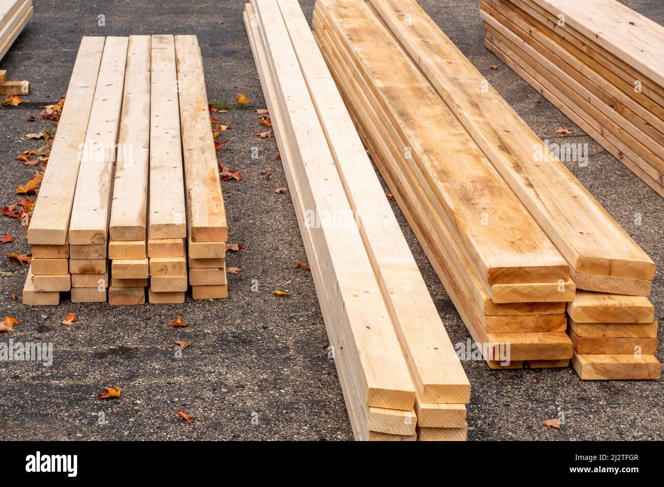 Holz wird in einer Auffahrt gestapelt, die gerade für den Beginn eines neuen Zubauprojekts geliefert wurde Stockfoto