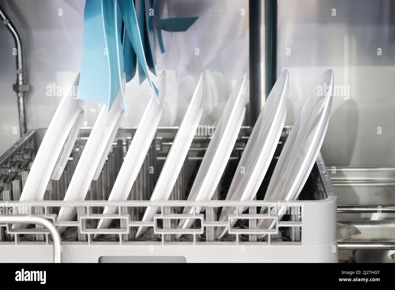 Die automatische Spülmaschine mit weißen, sauberen Gerichten im Korb. Für Restaurant. Geschäftlicher industrieller Hintergrund Stockfoto