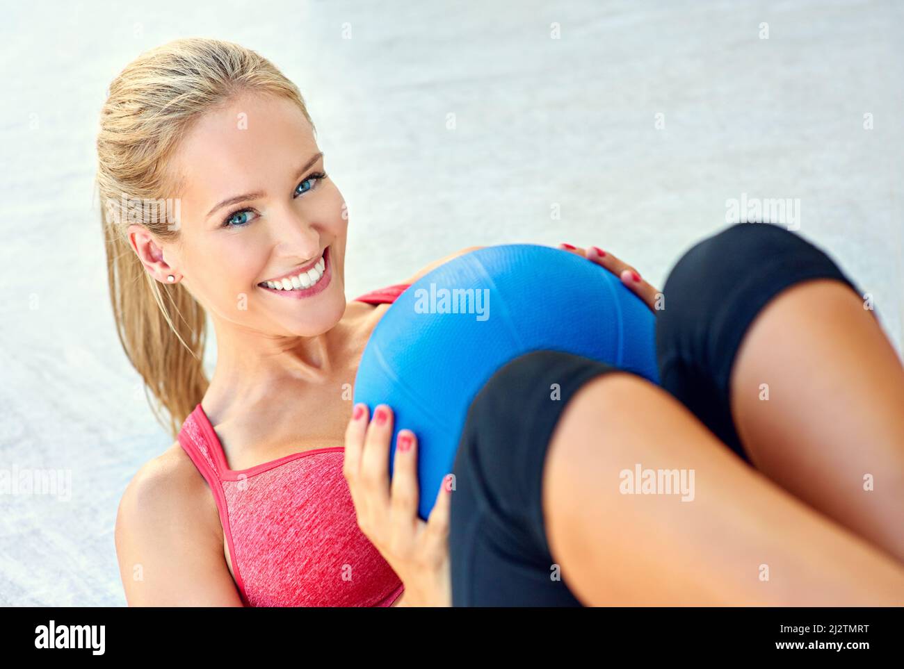 Arbeite diesen Körper. Beschnittenes Porträt einer jungen Frau, die mit einem Medizinball arbeitet. Stockfoto