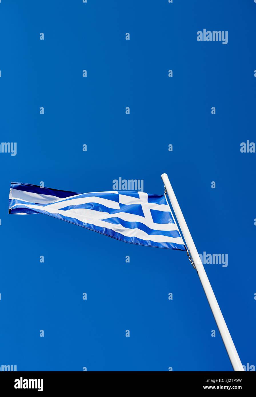 Stolz Auf Griechisch. Unterer Winkel der griechischen Flagge, die tagsüber auf sich allein gestellt steht. Stockfoto