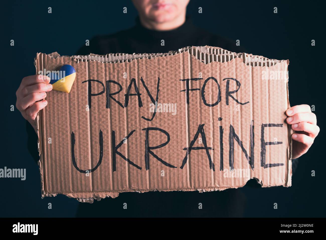 Frau hält ein Banner mit Anti-Kriegs-Botschaft. Protest gegen die russische Intervention in der Ukraine, Aktivismus und Menschenrechtsbewegung. Konzept der Standi Stockfoto