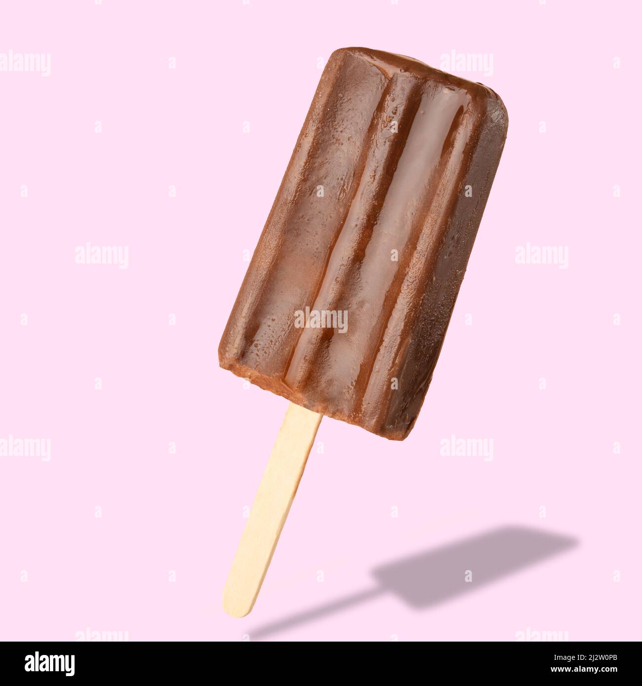 Schokoladenpopsicle auf den Stäbchen, gefrorener Saft. Helle Farbe, Sommerstimmung. Eis, Frische, isolieren, auf einem rosa Hintergrund Stockfoto