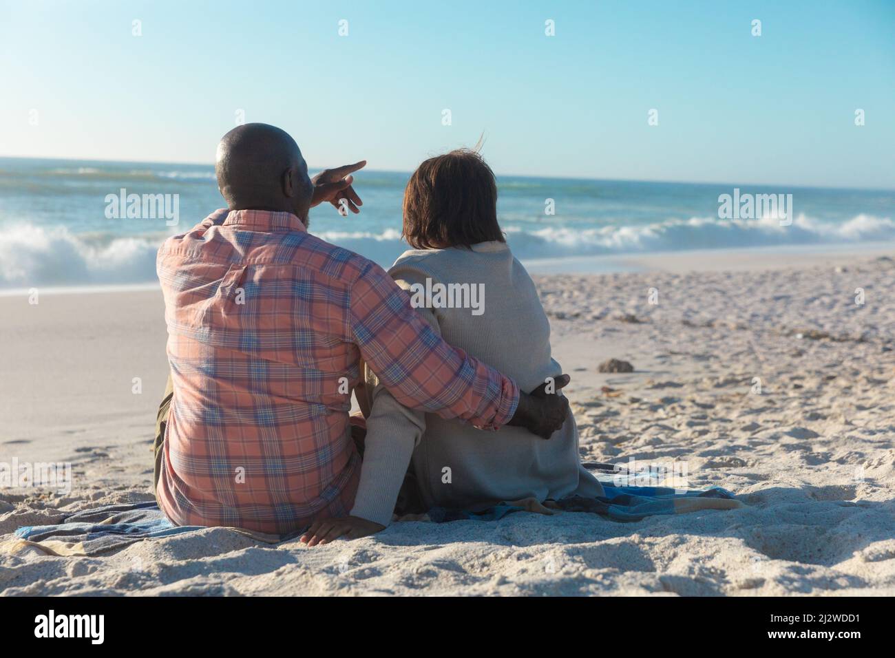 Rückansicht des afroamerikanischen Senioren-Paares, das gemeinsam am Strand Freizeit verbringt Stockfoto