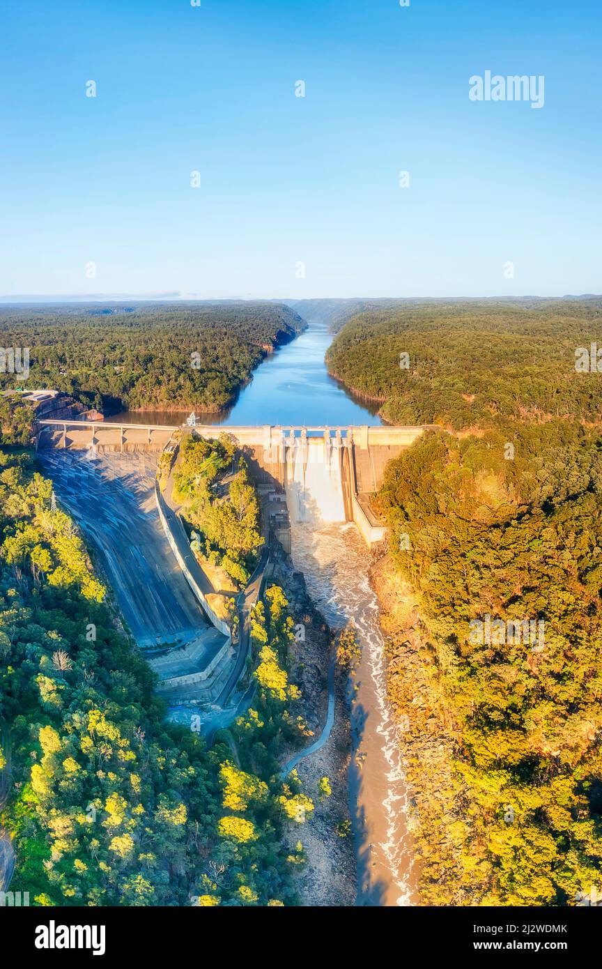 Überlaufender Warragamba-Staudamm am Blue Mountains-Fluss in Australien - vertikales Luftpanorama. Stockfoto