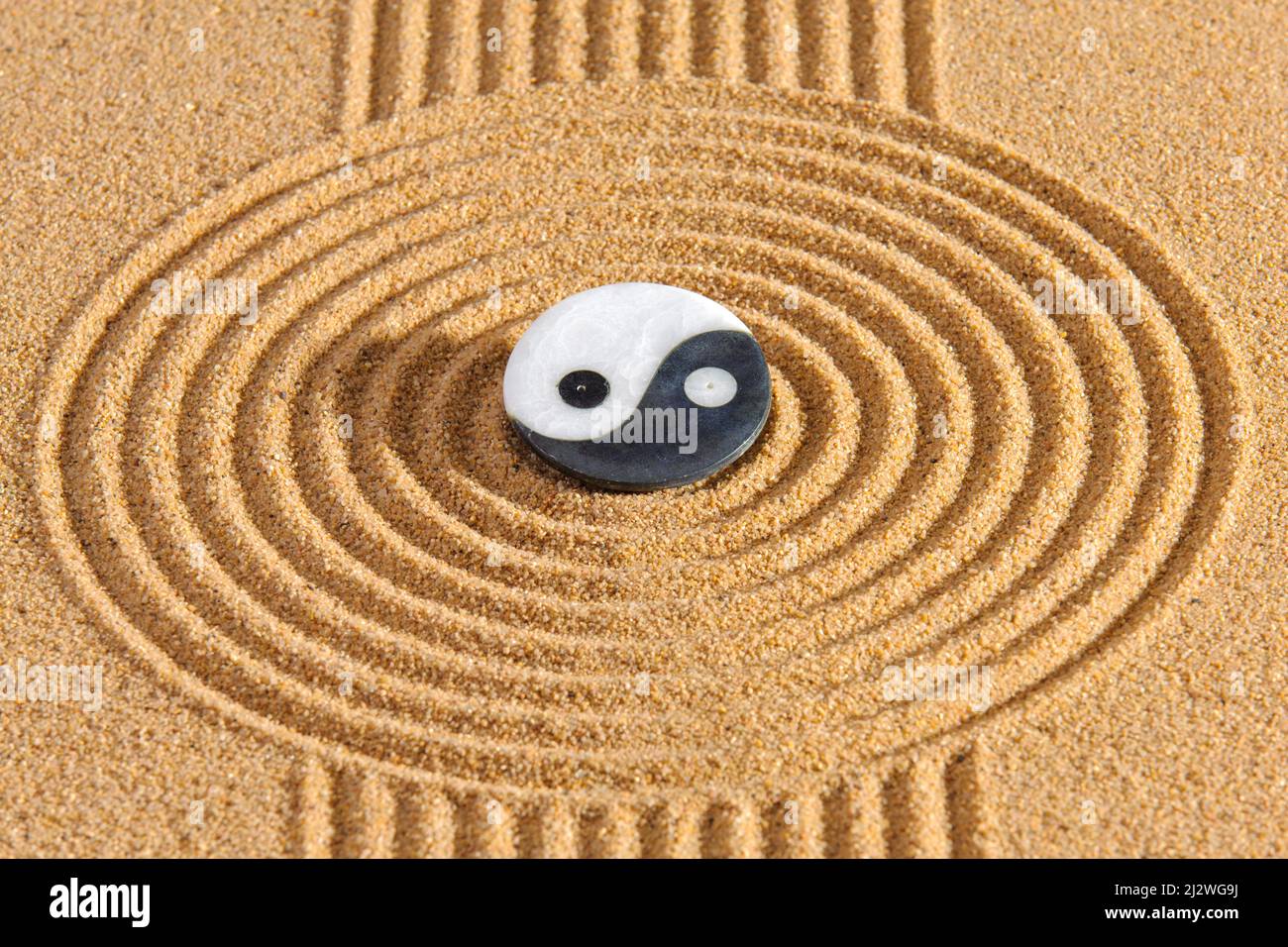 Japanischer Zen-Garten mit Yin und Yang und feng Shui in strukturiertem Sand Stockfoto