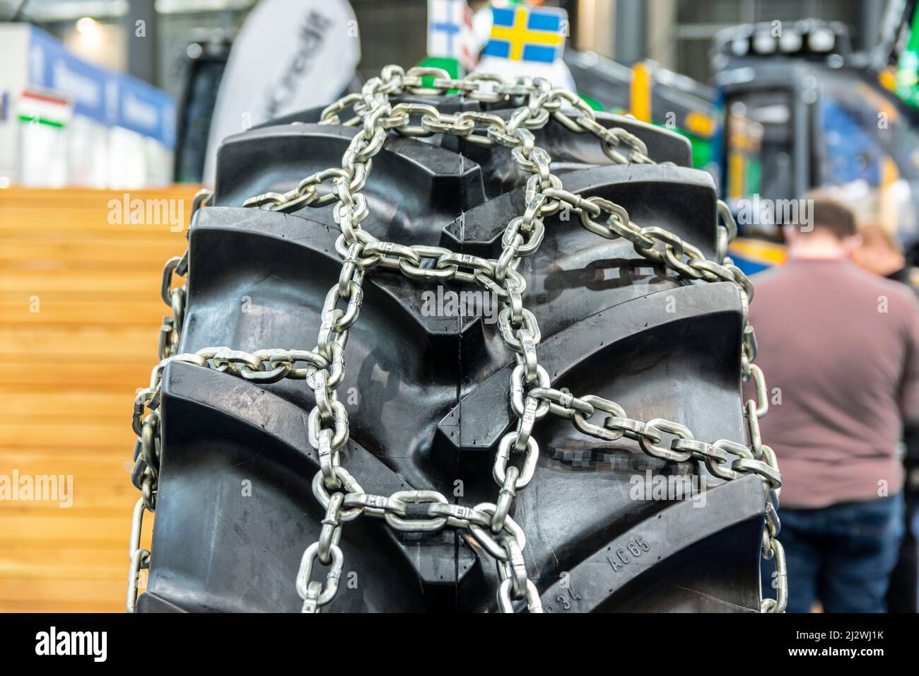 Nahaufnahme einiger Traktorräder mit Reifenkette. Brandneue Traktor- und Ladereifen. Stockfoto