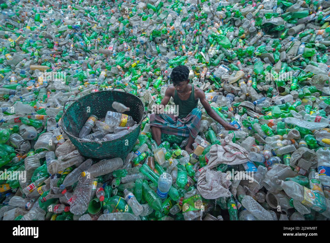 Noakhali, Chittagong, Bangladesch. 4. April 2022, Noakhali, Chittagong, Bangladesch: Ein Arbeiter sortiert gebrauchte Plastikflaschen in einer Recyclingfabrik in Noakhali, Bangladesch. Plastikflaschen, die zur Verpackung von Wasser verwendet werden, brauchen mehr als 1.000 Jahre, um biologisch abbaulich zu werden und, wenn sie verbrannt werden, giftige Dämpfe zu erzeugen. Schwimmende Kunststoffabfälle, die Tausende von Jahren im Wasser überleben können, dienen als Mini-Transportmittel für invasive Arten und stören Lebensräume. Tief in Deponien vergrabener Kunststoff kann schädliche Chemikalien austreten, die sich in das Grundwasser ausbreiten. Kredit: ZUMA Press, Inc./Alamy Live Nachrichten Stockfoto