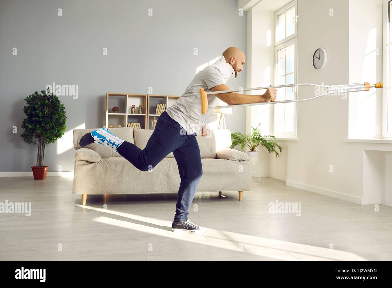 Glücklicher Mann mit gebrochenem Hals und anderen Verletzungen, der Spaß hat, während er sich zu Hause erholt Stockfoto