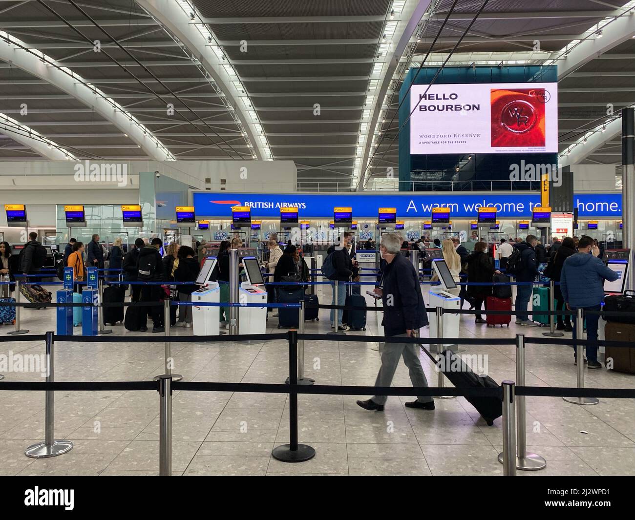 Die Leute, die am Heathrow Terminal 5 in der Warteschlange zum Check-in standen, als Reisende, die am Montag auf Auslandsreisen eintrafen, einem Chaos ausgesetzt waren, da Flüge gestrichen wurden und der Cross-Channel-Bahnverkehr von großen Verspätungen betroffen war. Fluggesellschaften leiden unter Personalmangel im Zusammenhang mit der Coronavirus-Krankheit, was zu einer Flugerdung führt. Bilddatum: Montag, 4. April 2022. Stockfoto