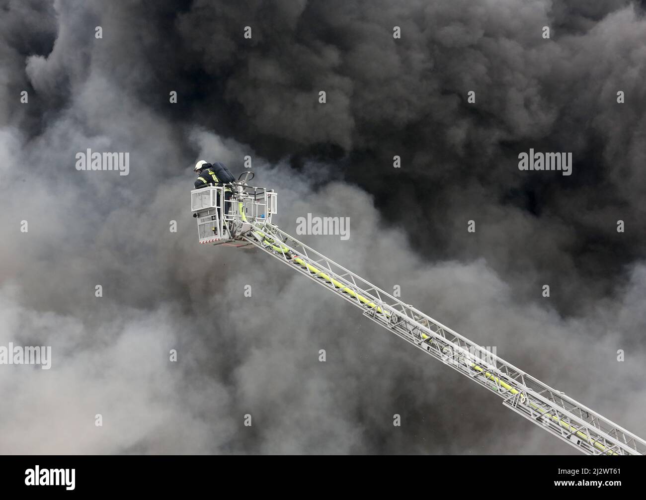 Mulheim, Deutschland. 04. April 2022, Nordrhein-Westfalen, Mülheim an der Ruhr: Die Feuerwehr löscht den Brand in einem Lagerhaus. Ein Kinderkarussell auf einem LKW-Anhänger hatte aus noch unbekannten Gründen Feuer gefangen. Aufgrund der starken Rauchentwicklung wurden Warnmeldungen über die Warnungs-App Nina veröffentlicht. Foto: Roland Weihrauch/dpa Quelle: dpa picture Alliance/Alamy Live News Stockfoto