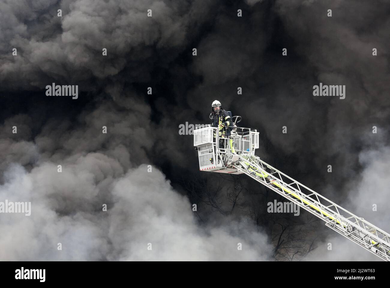 Mulheim, Deutschland. 04. April 2022, Nordrhein-Westfalen, Mülheim an der Ruhr: Die Feuerwehr löscht den Brand in einem Lagerhaus. Ein Kinderkarussell auf einem LKW-Anhänger hatte aus noch unbekannten Gründen Feuer gefangen. Aufgrund der starken Rauchentwicklung wurden Warnmeldungen über die Warnungs-App Nina veröffentlicht. Foto: Roland Weihrauch/dpa Quelle: dpa picture Alliance/Alamy Live News Stockfoto