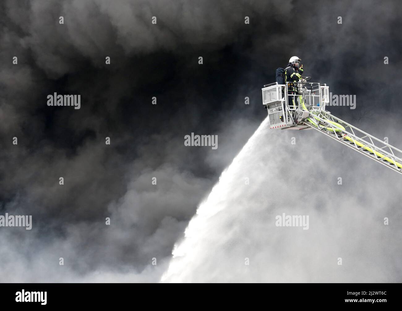 Mulheim, Deutschland. 04. April 2022, Nordrhein-Westfalen, Mülheim an der Ruhr: Die Feuerwehr löscht den Brand in einem Lagerhaus. Ein Kinderkarussell auf einem LKW-Anhänger hatte aus noch unbekannten Gründen Feuer gefangen. Aufgrund der starken Rauchentwicklung wurden Warnmeldungen über die Warnungs-App Nina veröffentlicht. Foto: Roland Weihrauch/dpa Quelle: dpa picture Alliance/Alamy Live News Stockfoto