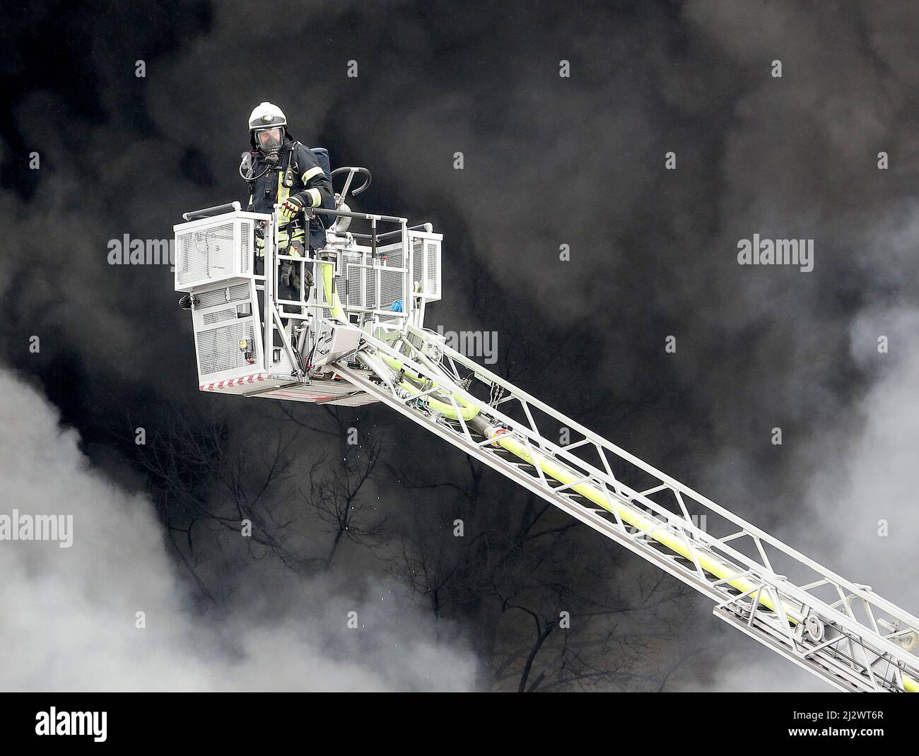 Mulheim, Deutschland. 04. April 2022, Nordrhein-Westfalen, Mülheim an der Ruhr: Die Feuerwehr löscht den Brand in einem Lagerhaus. Ein Kinderkarussell auf einem LKW-Anhänger hatte aus noch unbekannten Gründen Feuer gefangen. Aufgrund der starken Rauchentwicklung wurden Warnmeldungen über die Warnungs-App Nina veröffentlicht. Foto: Roland Weihrauch/dpa Quelle: dpa picture Alliance/Alamy Live News Stockfoto