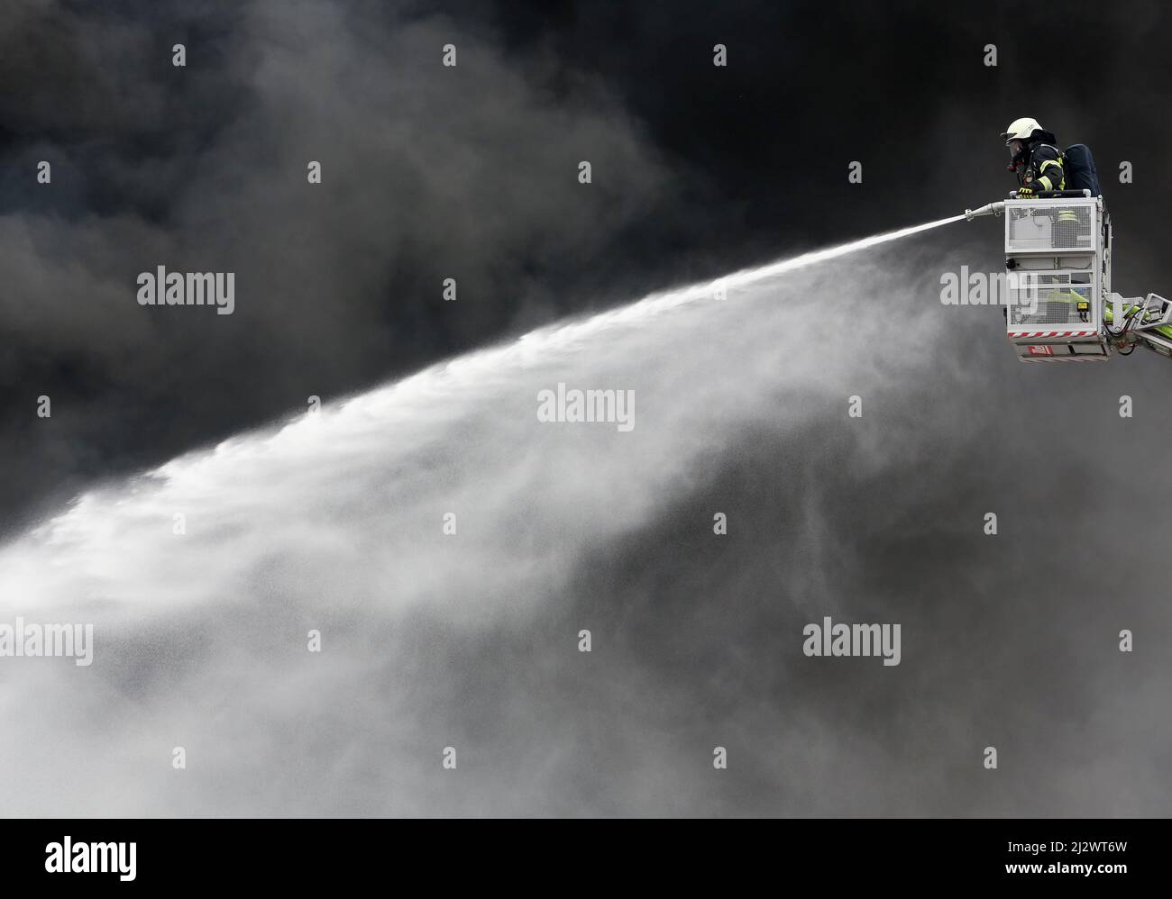 Mulheim, Deutschland. 04. April 2022, Nordrhein-Westfalen, Mülheim an der Ruhr: Die Feuerwehr löscht den Brand in einem Lagerhaus. Ein Kinderkarussell auf einem LKW-Anhänger hatte aus noch unbekannten Gründen Feuer gefangen. Aufgrund der starken Rauchentwicklung wurden Warnmeldungen über die Warnungs-App Nina veröffentlicht. Foto: Roland Weihrauch/dpa Quelle: dpa picture Alliance/Alamy Live News Stockfoto