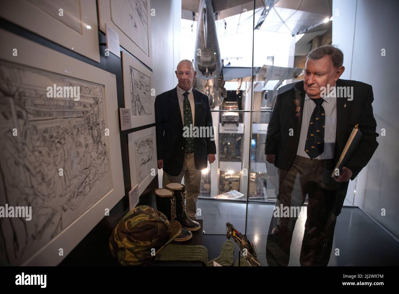 NEW FALKLANDS DISPLAYS ERÖFFNET IM IWM LONDON New Falklands Displays im IWM London, darunter Bilder des professionellen Fotografen Paul Haley und Kunstwerke von Linda Kitson. (Im Bild) Falklands-Veteran Mike Carr, der mit 3 para mit Paul Carr zusammen mit Falklands-Veteran Paul Benton, der an Bord der HMS Invincible diente, diente, stand neben einem Schaukasten, in dem Lara Kitsens Skizzierzeug und Armeekleidung zeigte, die sie während des Falklands-Konflikts verwendete. Kredit: Jeff Gilbert/Alamy Live Nachrichten Stockfoto