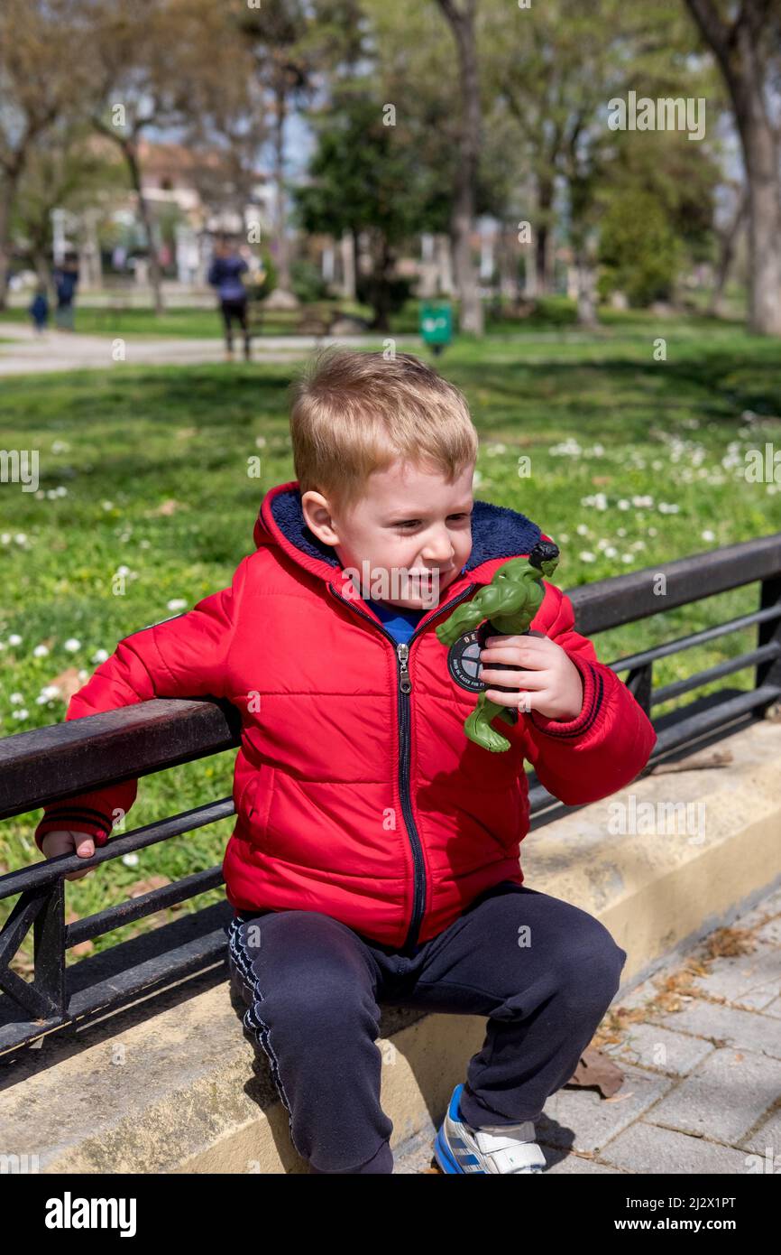 Netter kleiner Junge, der im Park mit seinem Spielzeug spielt Stockfoto