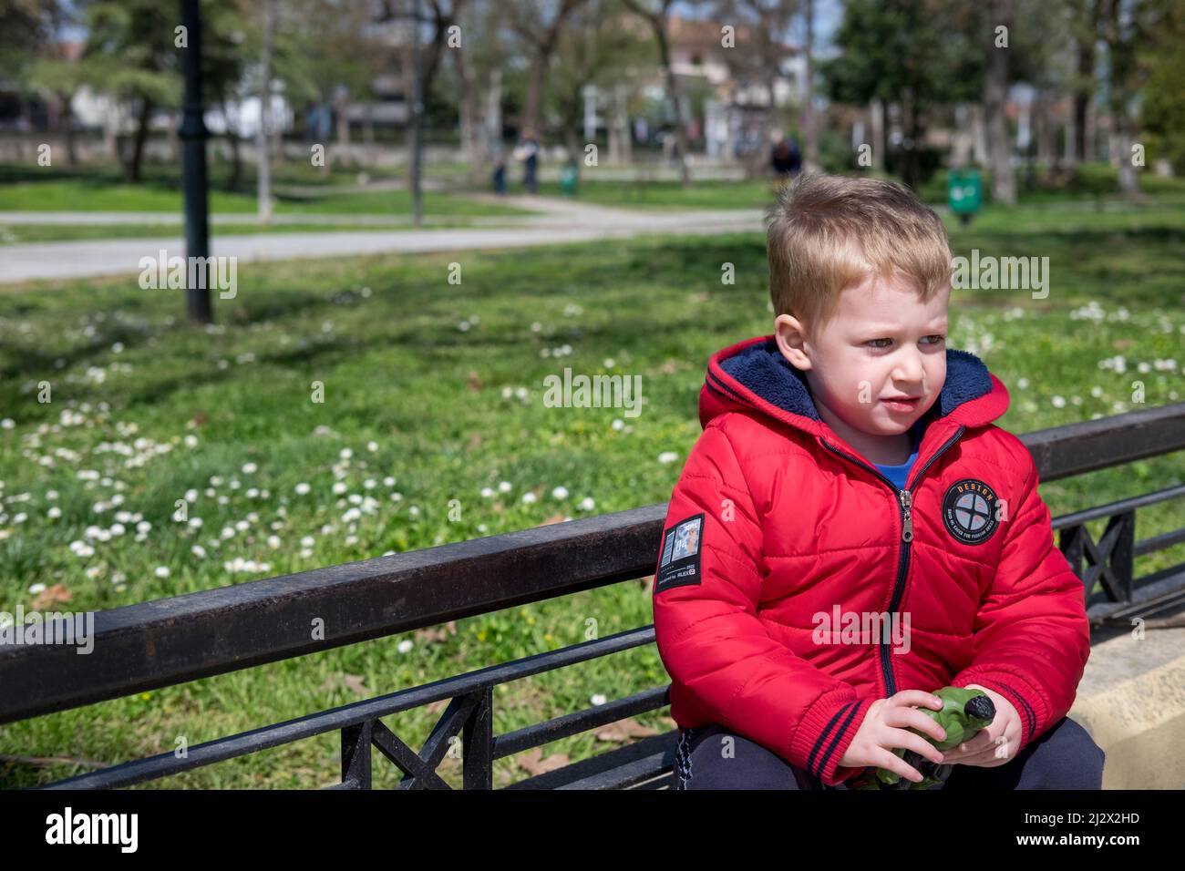 Netter kleiner Junge, der im Park mit seinem Spielzeug spielt Stockfoto
