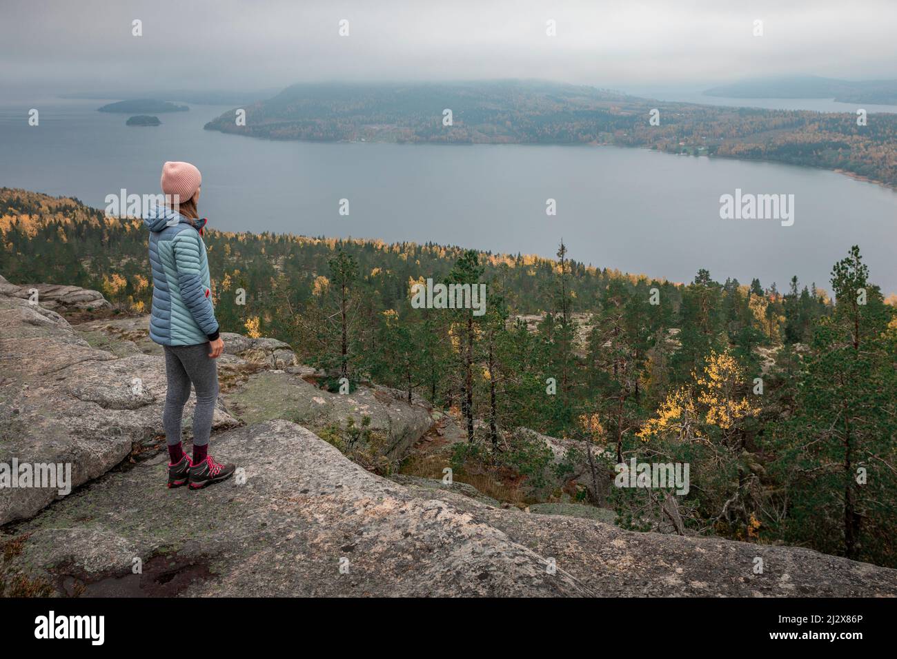 Frau auf dem Getsvedjeberget mit Blick über die Landschaft von Höga Kusten im Osten Schwedens Stockfoto