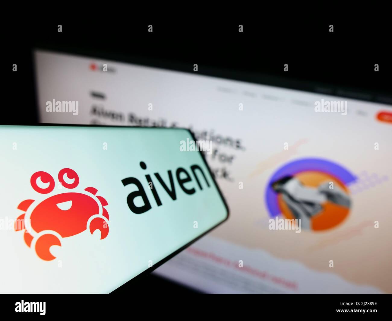 Smartphone mit Logo des IT-Unternehmens Aiven Oy auf dem Bildschirm vor der Business-Website. Konzentrieren Sie sich auf die linke Seite des Telefondisplays. Stockfoto