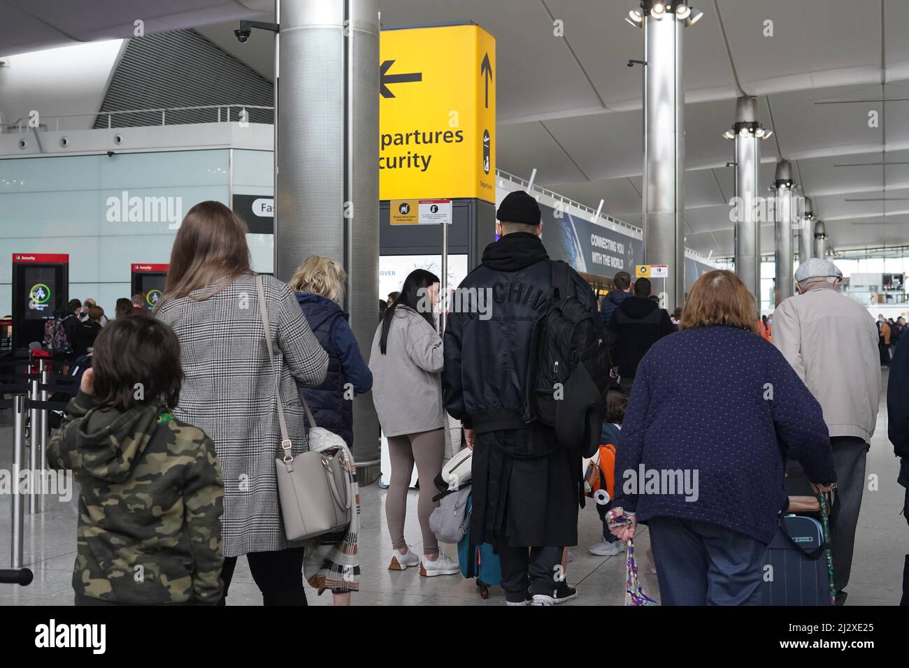 Die Leute, die Schlange standen, um am Heathrow Terminal 2 durch die Sicherheitskontrolle zu gehen, als Reisende, die am Montag auf Auslandsreisen eingingen, mit Chaos konfrontiert wurden, als Flüge gestrichen wurden und die grenzüberschreitenden Bahnverbindungen von großen Verzögerungen betroffen waren. Fluggesellschaften leiden unter Personalmangel im Zusammenhang mit der Coronavirus-Krankheit, was zu einer Flugerdung führt. Bilddatum: Montag, 4. April 2022. Stockfoto