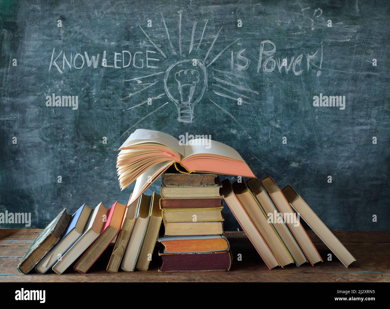Offenes Buch und Tafel mit Zeichnung einer Glühbirne und Slogan Wissen ist Macht, Lernen, Bildung, zurück zur Schule Konzept Stockfoto