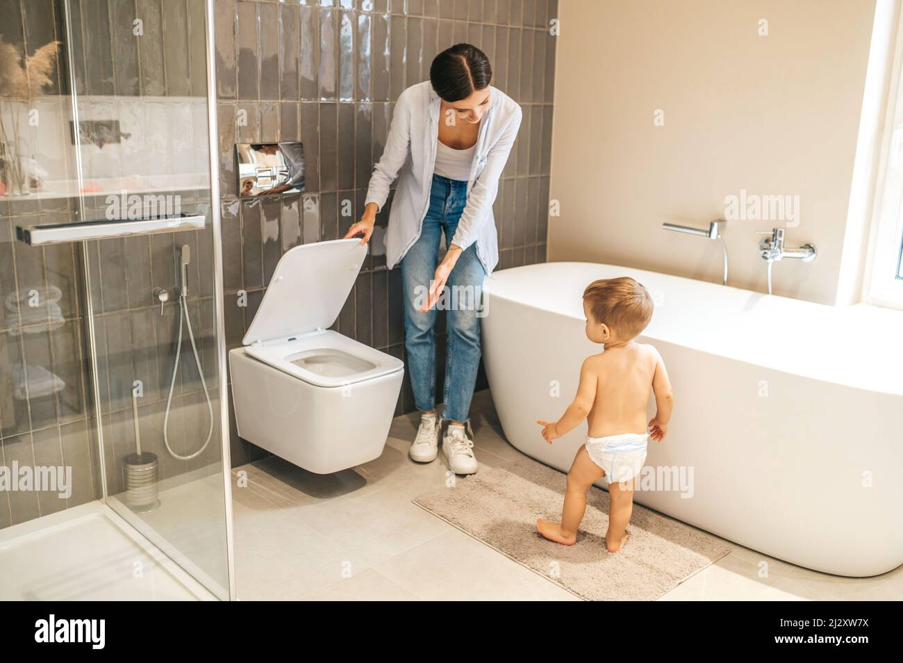 Fürsorgliche weibliche Eltern Toilette-Training ihren kleinen Jungen Stockfoto