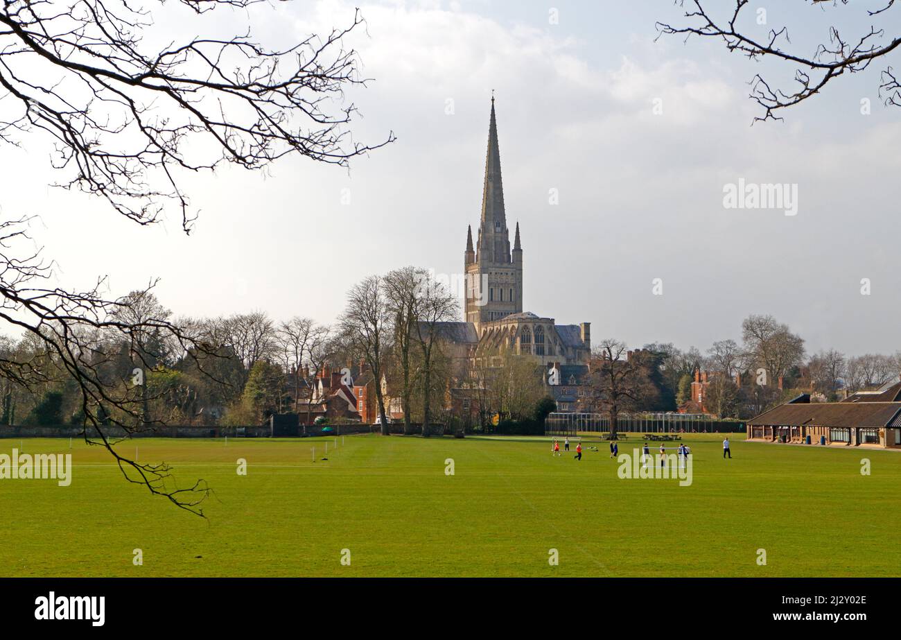 Blick auf die Kathedrale von der anderen Seite der Norwich School mit Fußballspielen für Kinder in der Stadt Norwich, Norfolk, England, Großbritannien. Stockfoto