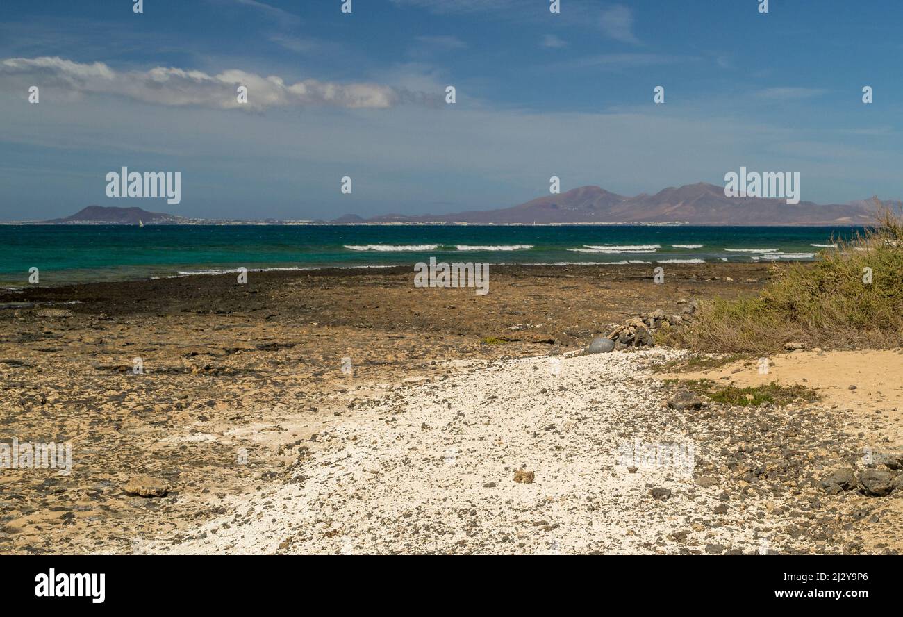 Weißer Sandstrand, Corralejo Fuerteventura mit Blick über das Meer der Insel Lobos und in weiter Ferne Playa Blanca auf Lanzarote Stockfoto