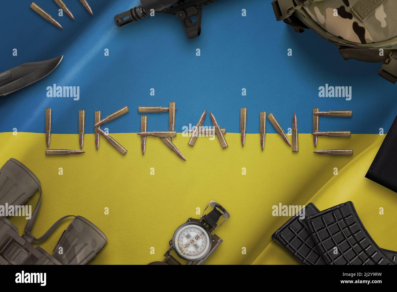 Munitionskonzept auf ukrainischer Flagge. Russisch-ukrainischer Konflikt. Schreibtisch mit ukrainischer Militärausrüstung. Draufsicht, flach liegend Stockfoto