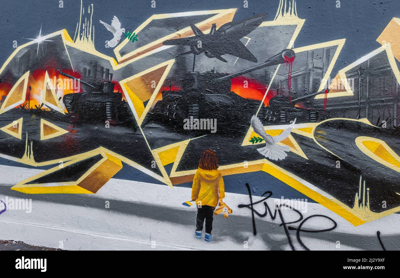 Mächtige Street Art in London von einem kleinen Mädchen, das den Konflikt in der Ukraine beobachtet, als er von Russland bombardiert wird. Stockfoto