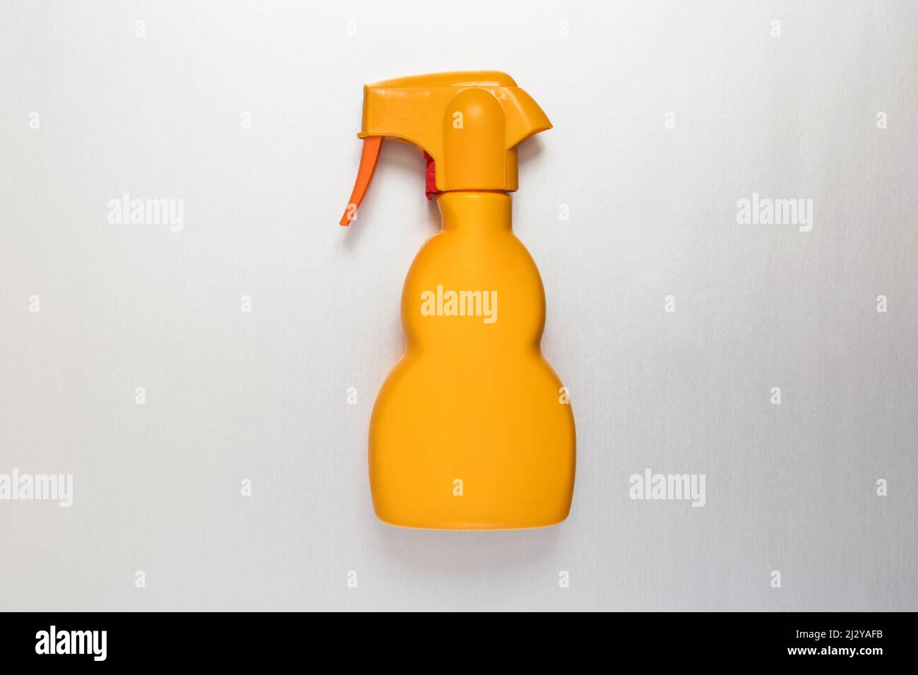 Generische, unbeschriftete gelbe Kunststoffsprühflasche, flach auf Weiß liegend, in einem Konzept der Einzelhandelsverpackung und der Haushaltshygiene mit Copyspace Stockfoto