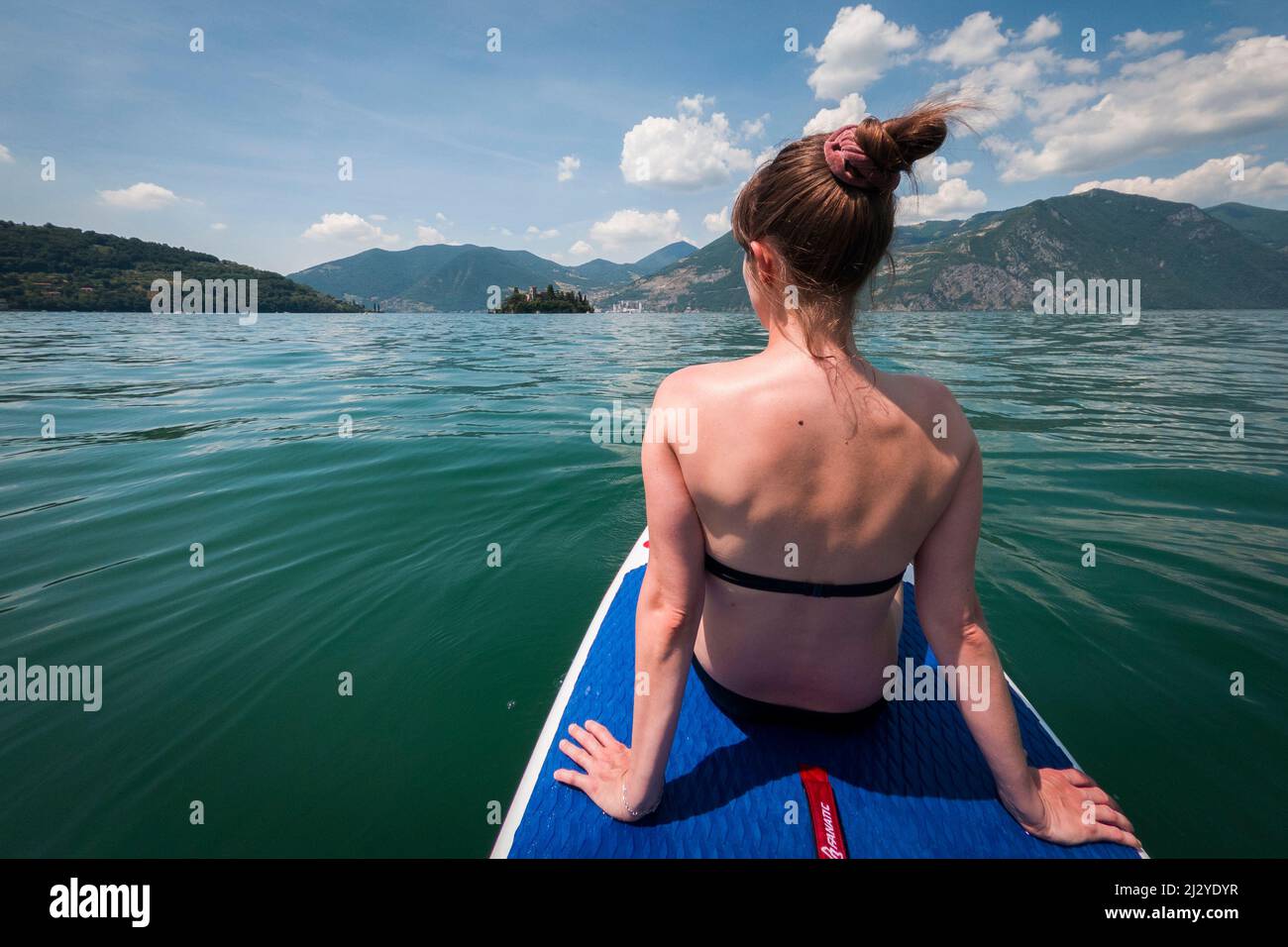 Frau auf dem SUP-Board im Wasser am Iseo-See, Italien Stockfoto