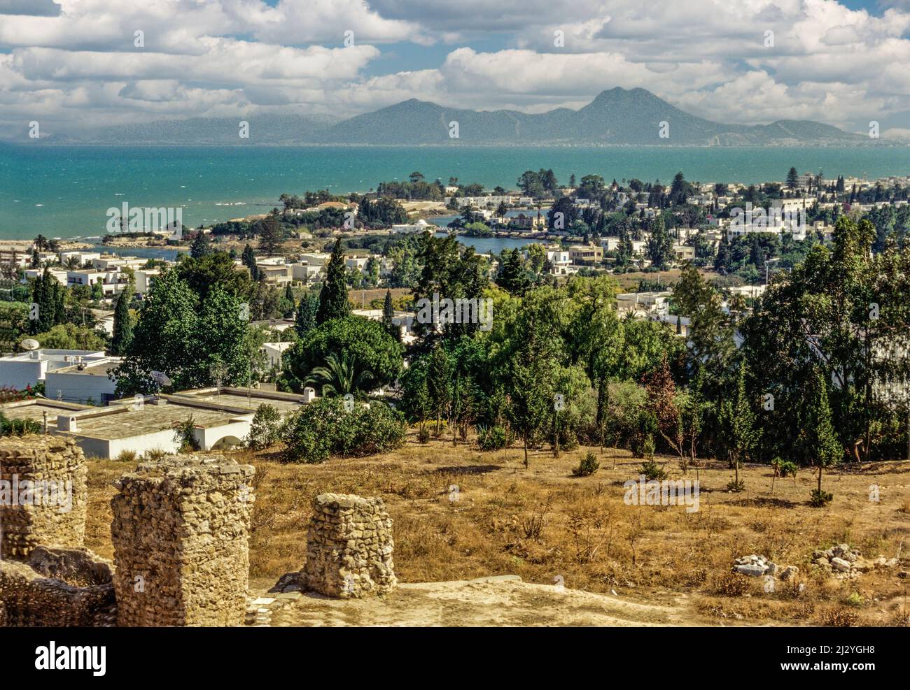 Karthago, Tunesien.  Punische Häfen, Datum jetzt kleine Seen, umgeben von luxuriösen Häuser ähneln vom 4.. Jahrhundert v. Chr.  Bucht von Tunis im Hintergrund. Stockfoto