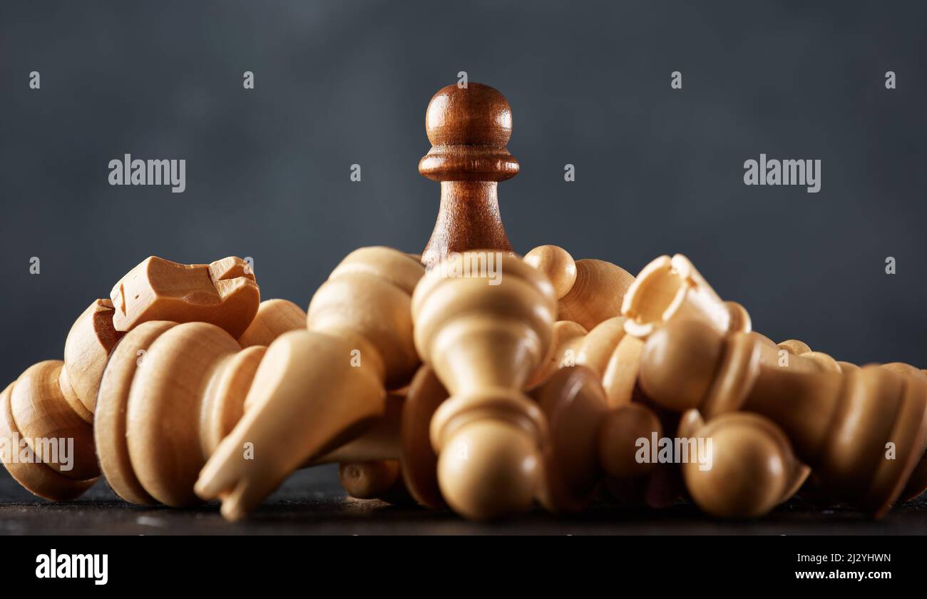 Der Bauer erhebt sich über das besiegte gegnerische Schachteam. Sieg, Erfolg, Erfolgsstrategie und Macht im Geschäftskonzept. Stockfoto