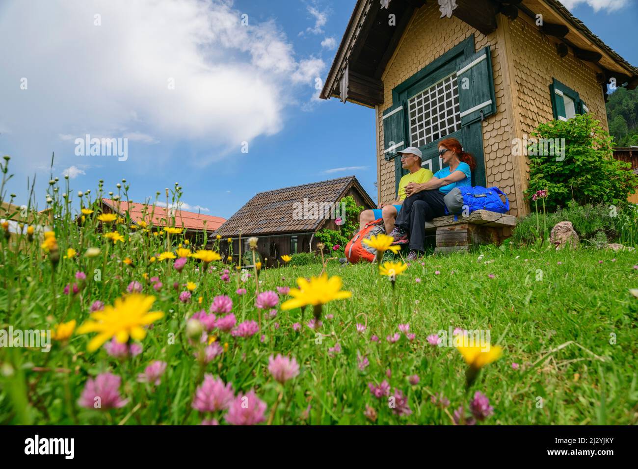 Mann und Frau sitzen beim Wandern vor einer kleinen Kapelle, Oberau, Berchtesgadener Alpen, Salzalpensteig, Oberbayern, Bayern, Deutschland Stockfoto