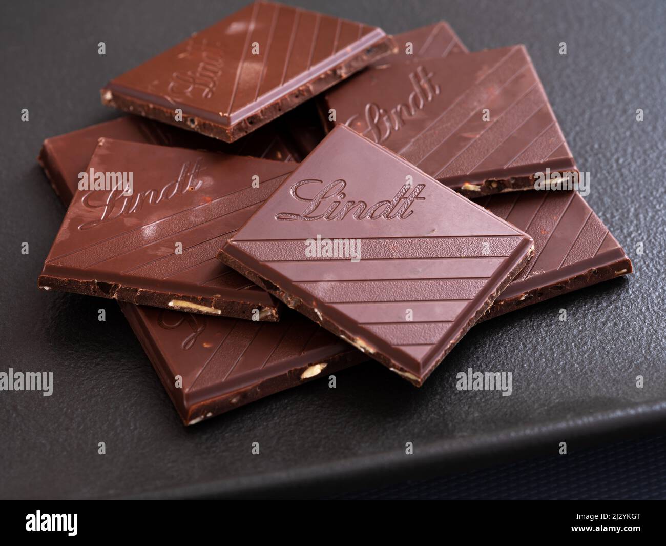 Tambow, Russische Föderation - 29. März 2022 Stücke Lindt Schokolade auf einem schwarzen Teller. Stockfoto