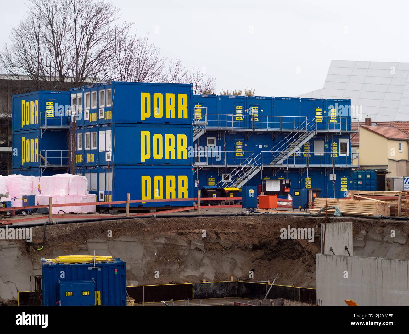 Auf einer Baustelle in der Stadt stapelten die Baukabinen der Firma PORR aufeinander. Blauer Behälter für Arbeiter und Materialien auf dem Boden. Stockfoto