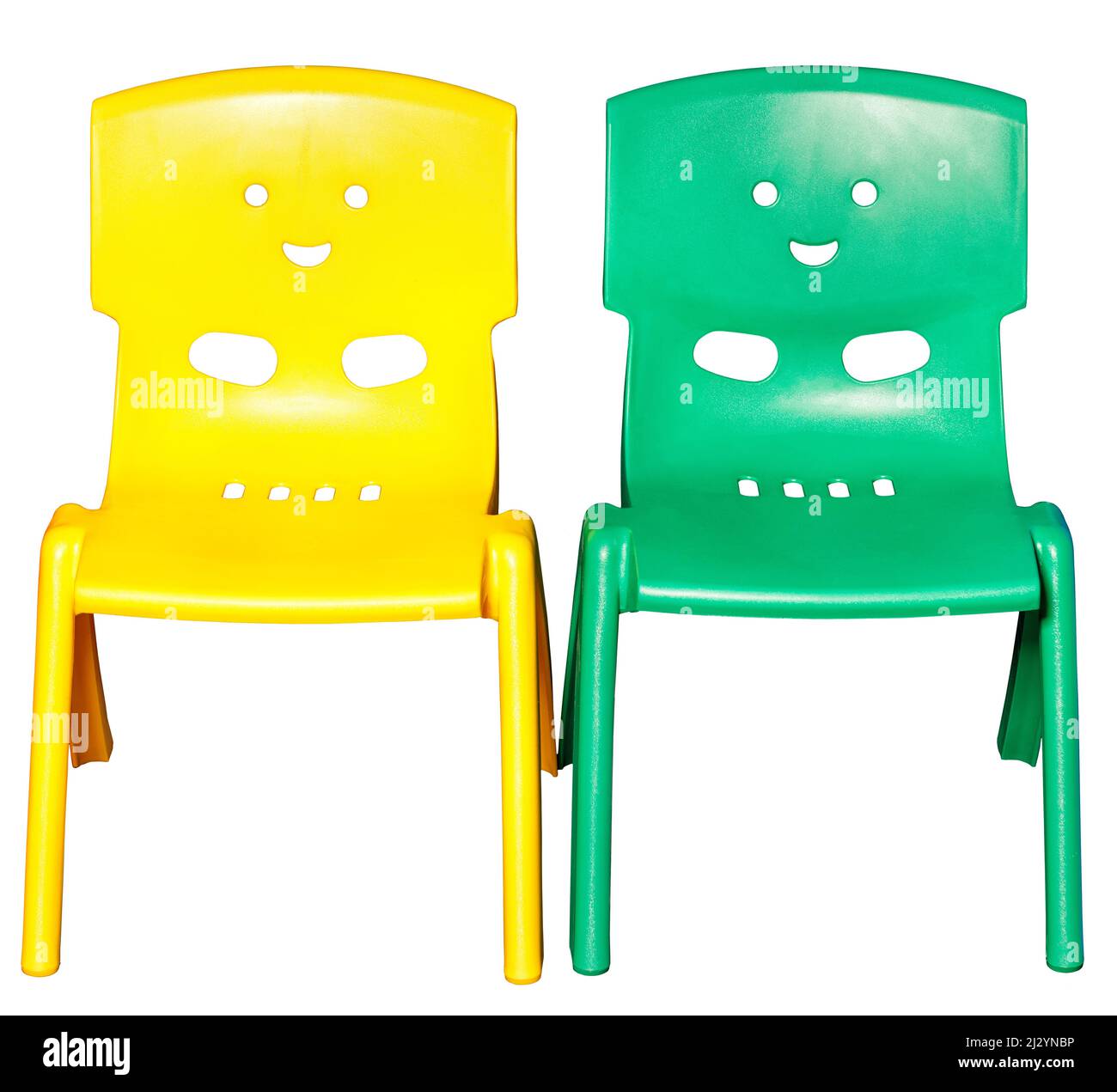 Zwei farbige Kinder-Plastikstühle gelb und grün mit lustigen Gesichtern auf der Rückseite. Isoliert auf weißem Hintergrund. Stockfoto
