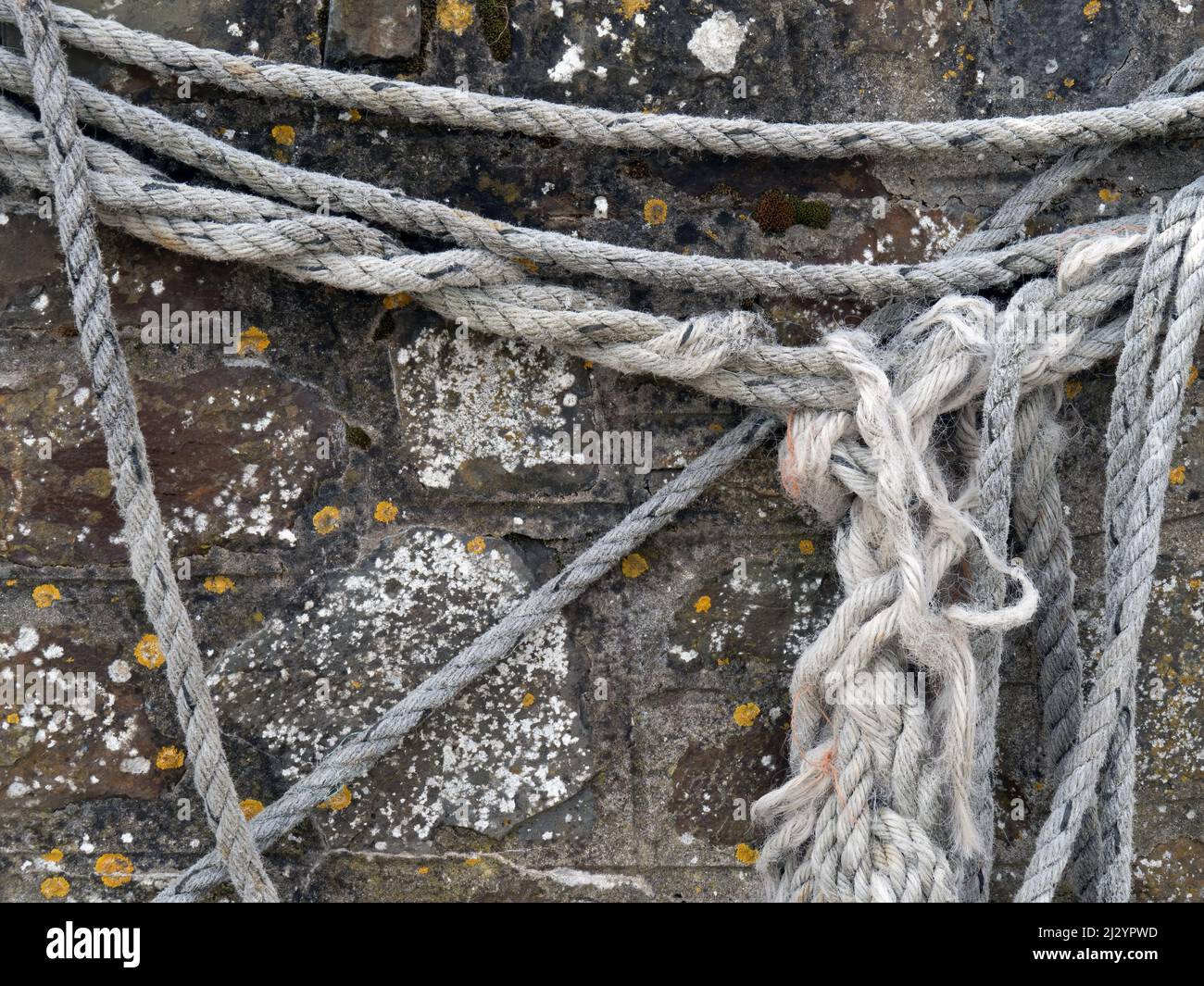 Altes Seil, Seile hängen an der Steinwand. Stockfoto