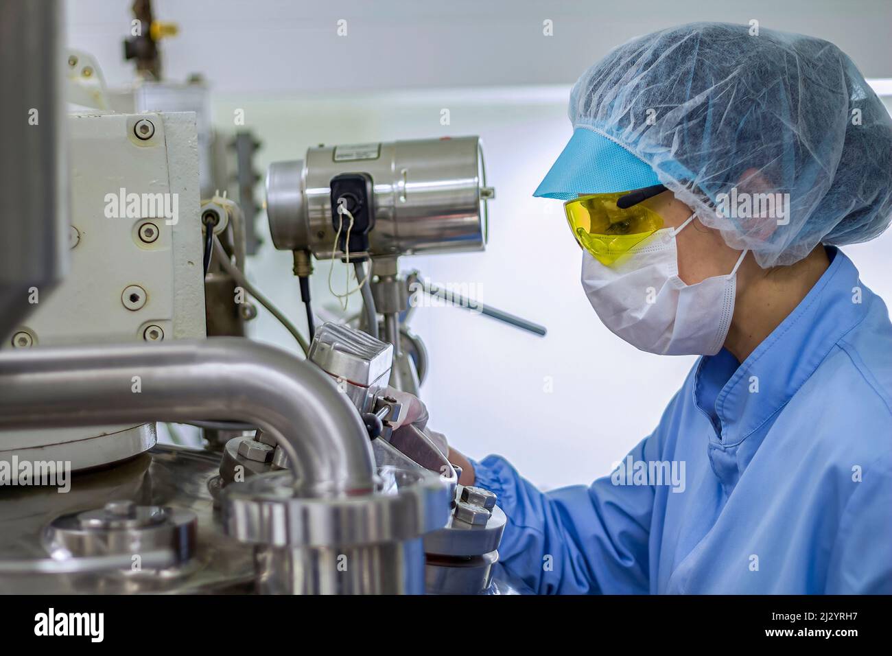 Pharma-Techniker arbeitet in sterile Arbeitsbedingungen an pharmazeutische Fabrik. Arbeitnehmerin tragen von Schutzkleidung. Stockfoto