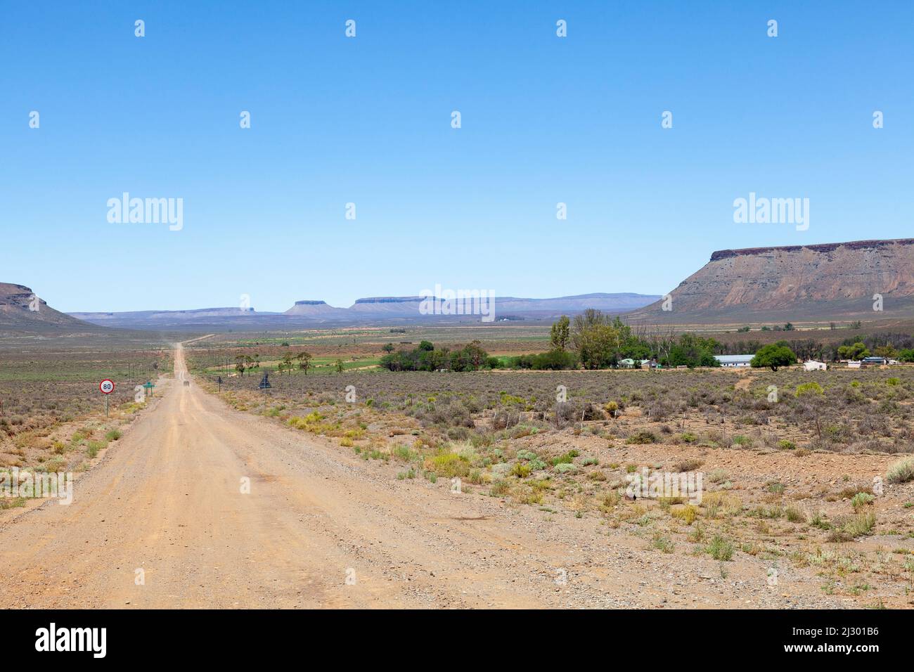 Landschaftlich reizvolle Karoo-Landschaft auf dem Weg nach Sutherland mit flachen Koppies und ländlichem Bauernhof, Südafrika Stockfoto