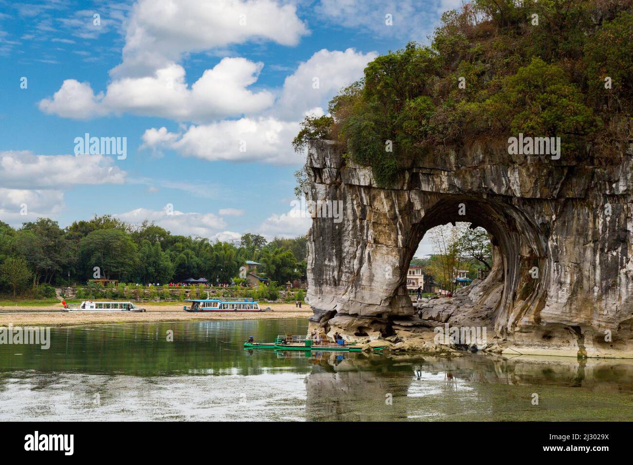Guilin, China.  Elephant Trunk Hill Park, Mond Arch.  Li-Fluss Kreuzfahrt Boote im Hintergrund. Stockfoto